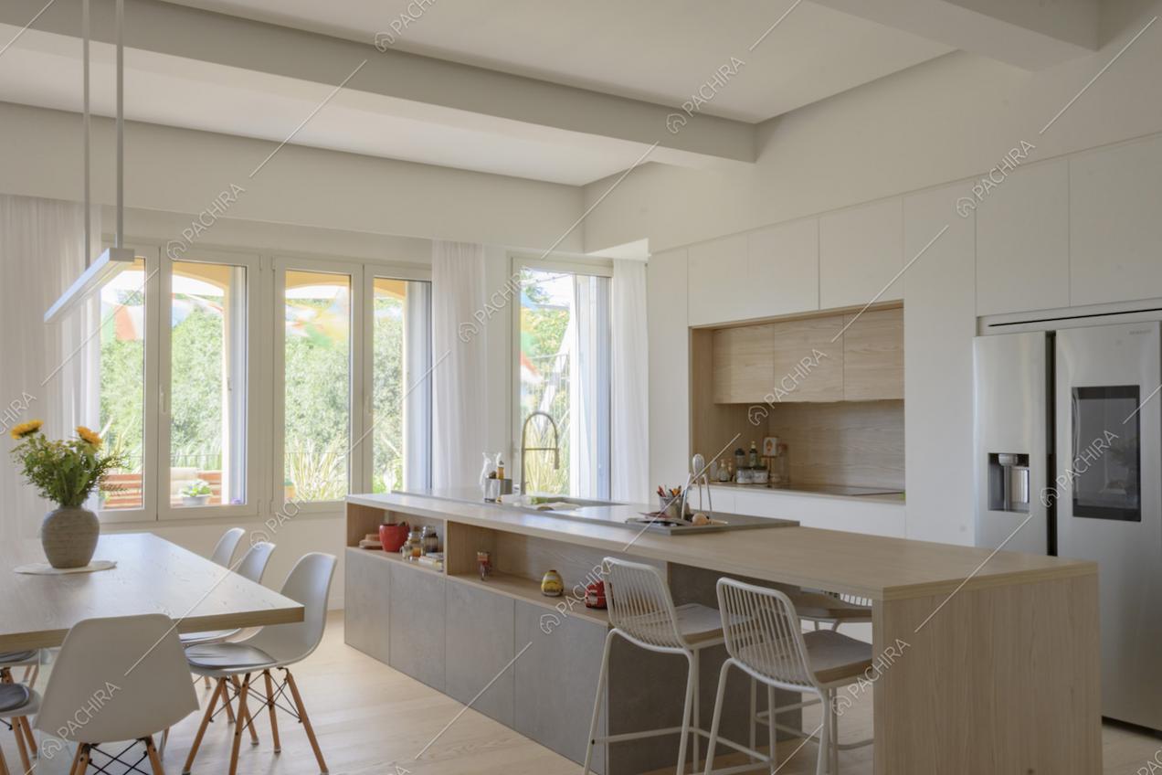 Open space con cucina a isola e sgabelli alti