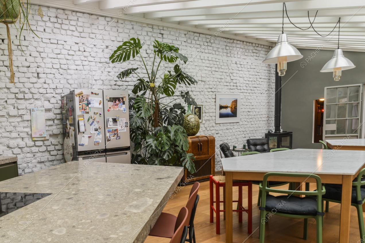 Cucina con isola dal piano in marmo e vista sulla sala da pranzo