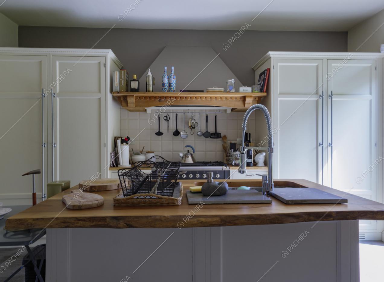Cucina a isola con piano da lavoro in legno e fornelli a gas