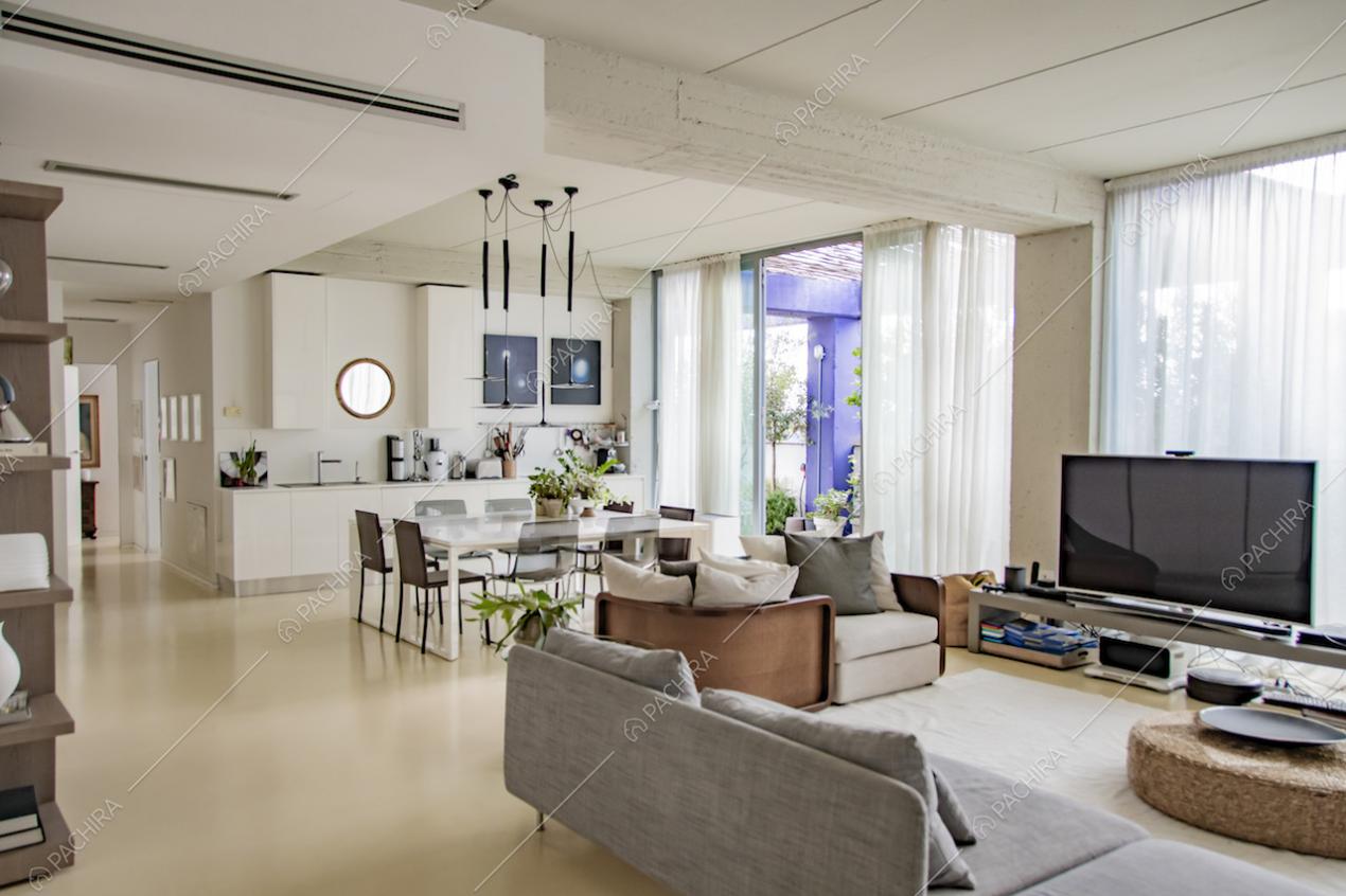 Zona giorno open space con cucina a vista, tavolo e divani