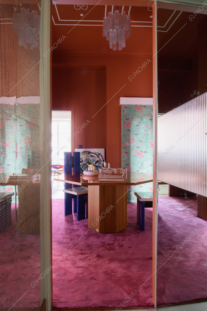Dal bagno vista sull'atrio dalle pareti arancioni con tavolo ottagonale e pavimento in moquette