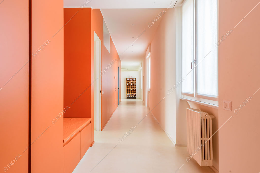 Corridoio dalle nuances arancioni dell'appartamento Papagayo, location in stile contemporaneo a Milano