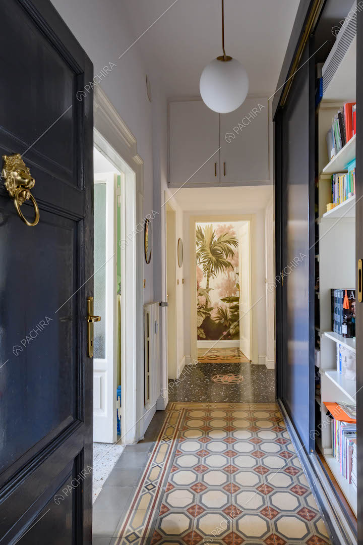 Dalla porta d'ingresso corridoio con pavimento in graniglia e libreria