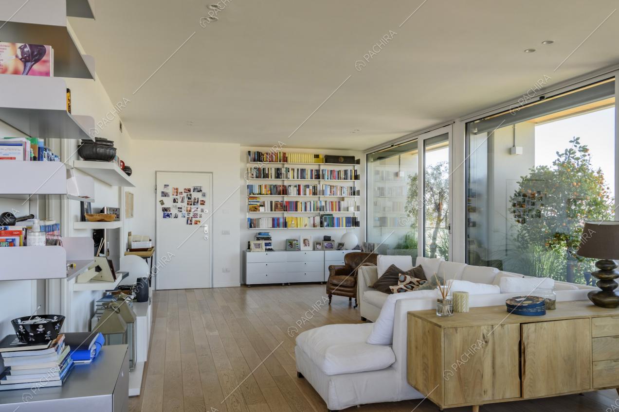 Salotto luminoso con divano bianco e libreria