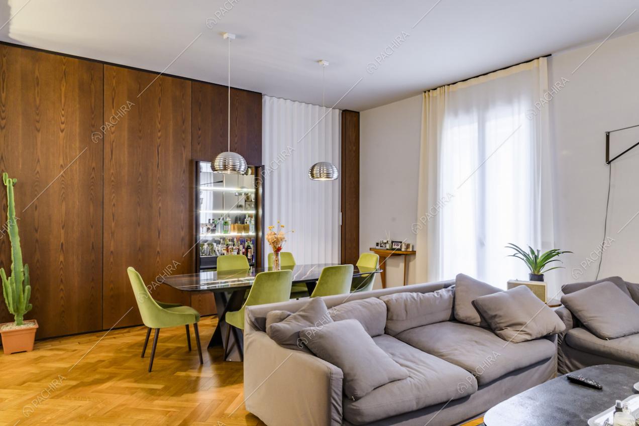Zona living con tavolo da pranzo di design e divani grigi