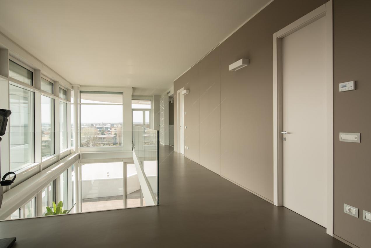 Pareti color grigio chiaro e grandi finestre