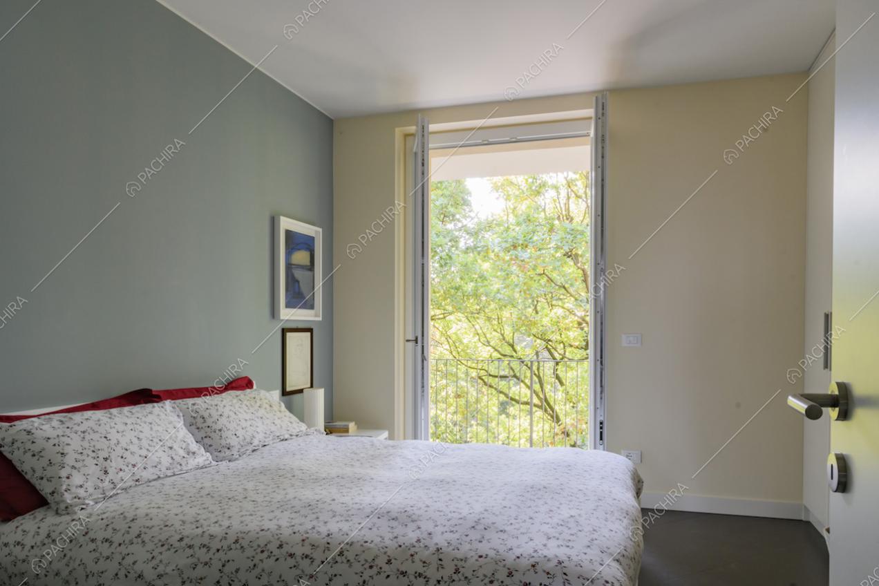 Camera da letto dai toni neutri con vista sul giardino