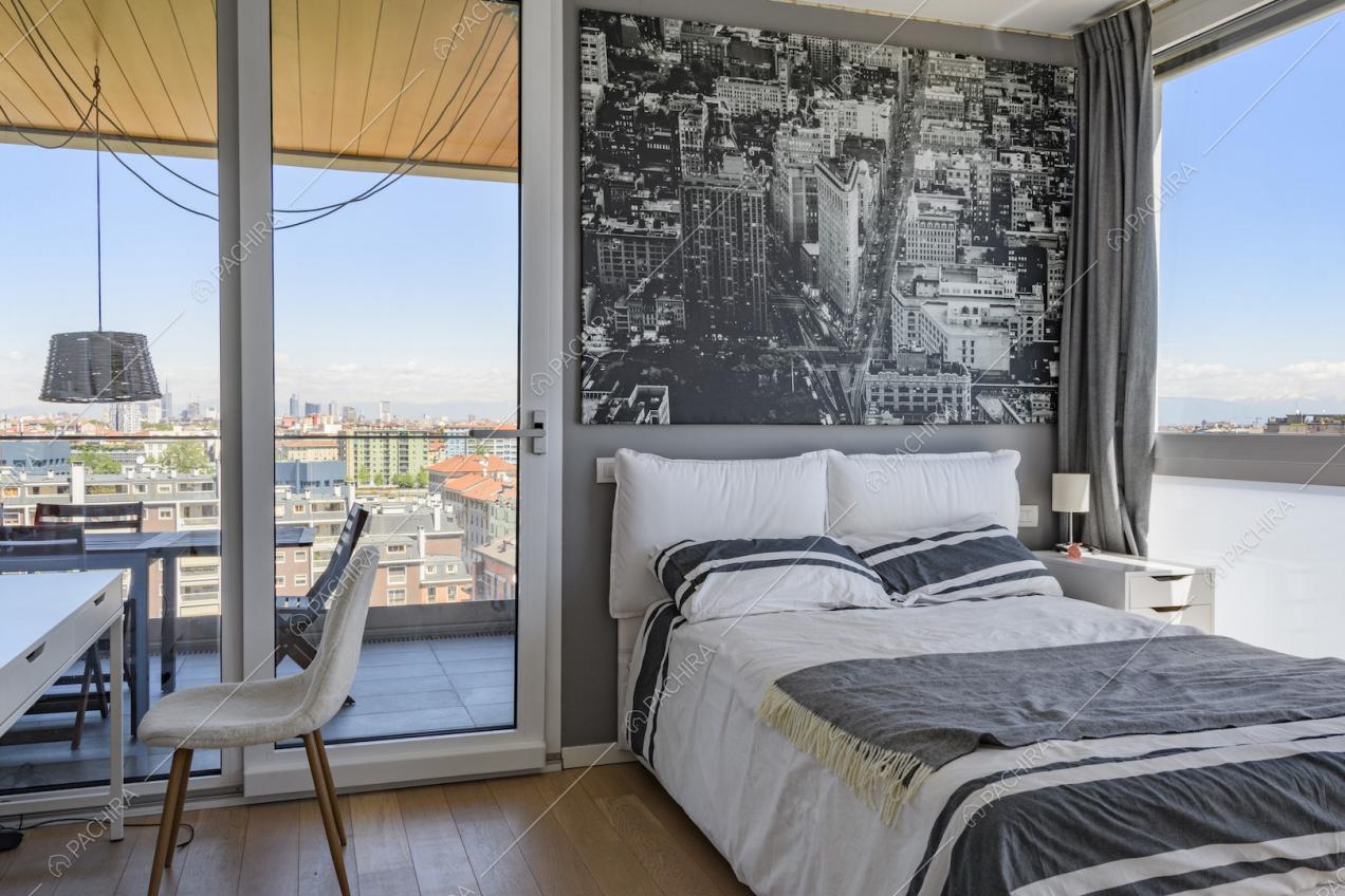 Camera da letto con grandi finestre e parquet