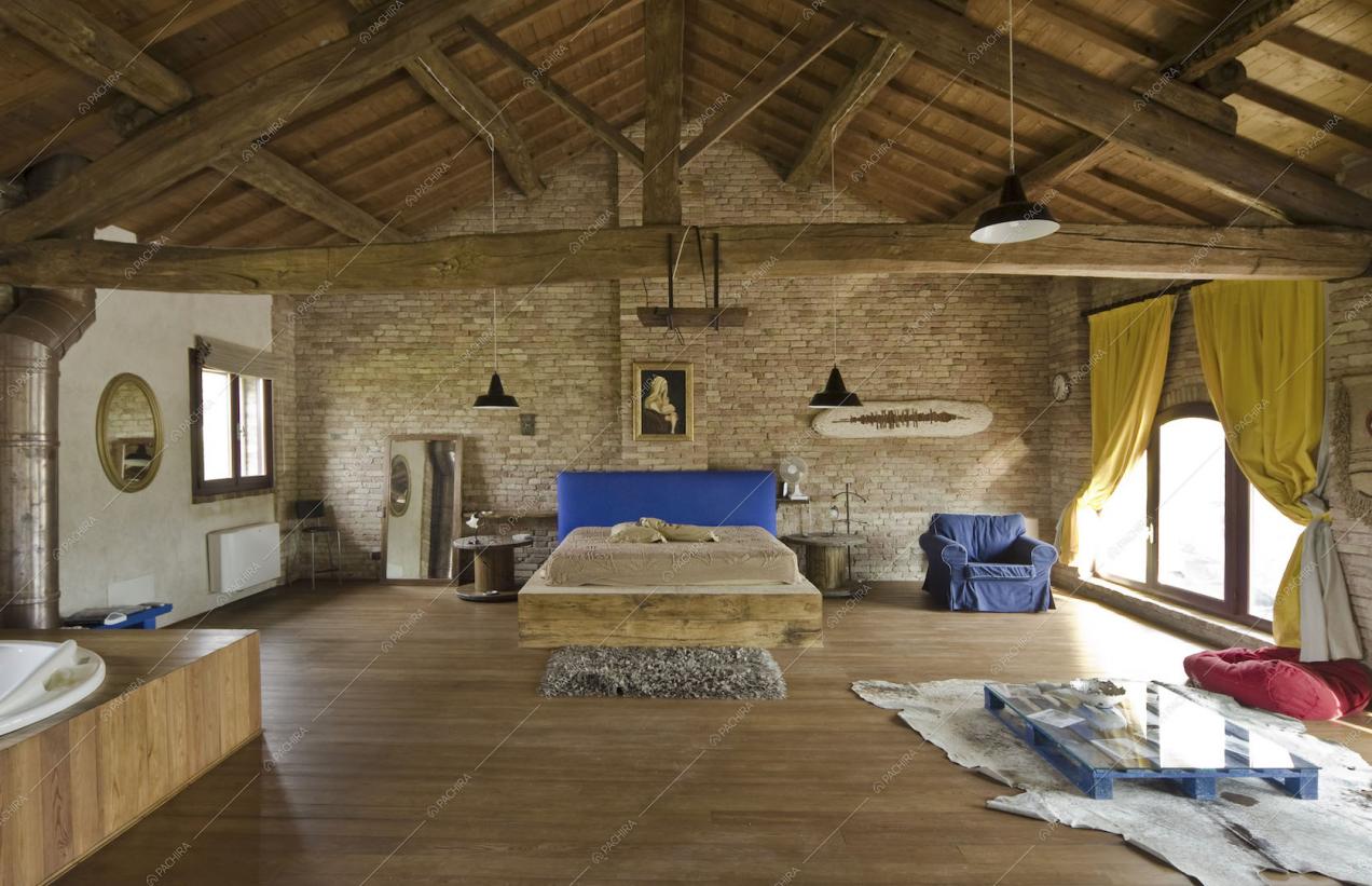 Camera da letto con letto matrimoniale su una struttura di legno, parquet