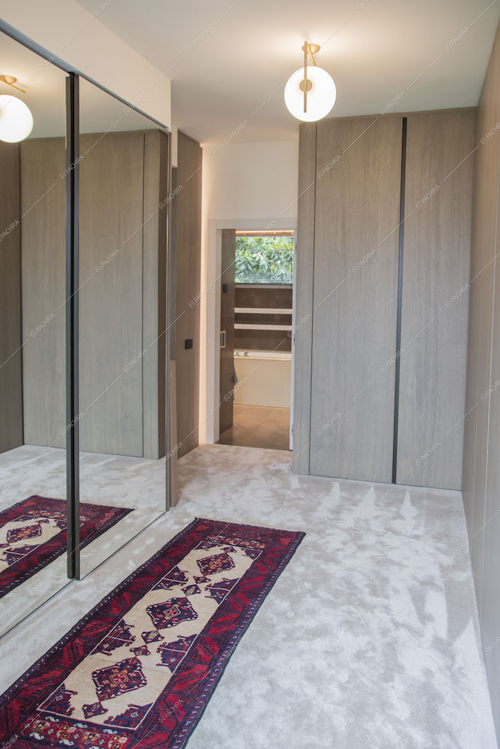 Cabina armadio con moquette sul pavimento e armadio con ante scorrevoli