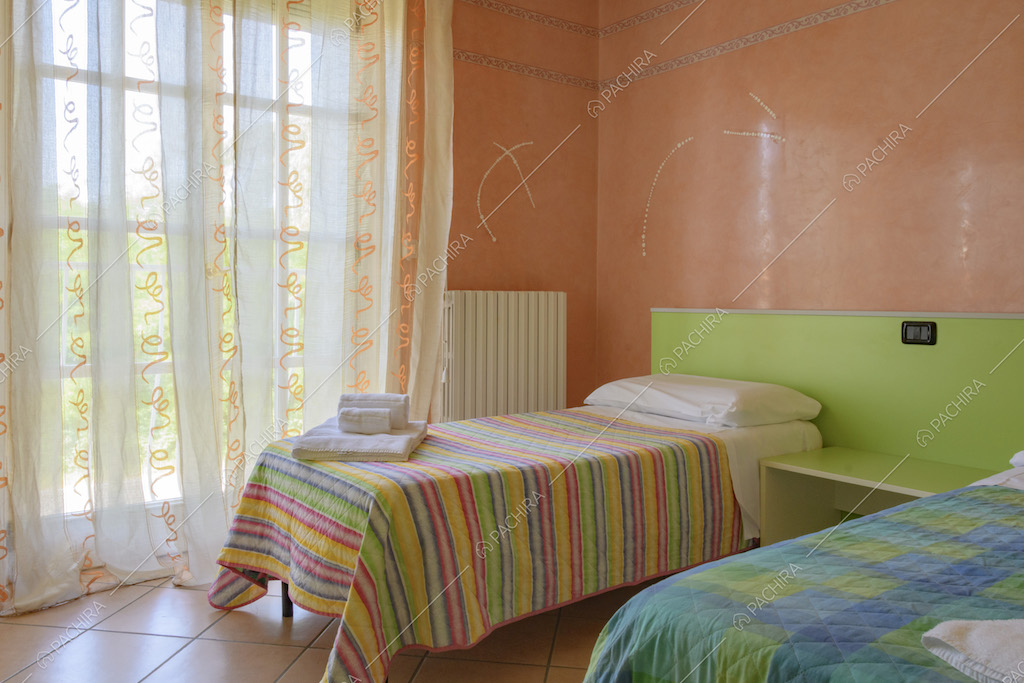 Camera da letto con due letti e tendaggio con decori