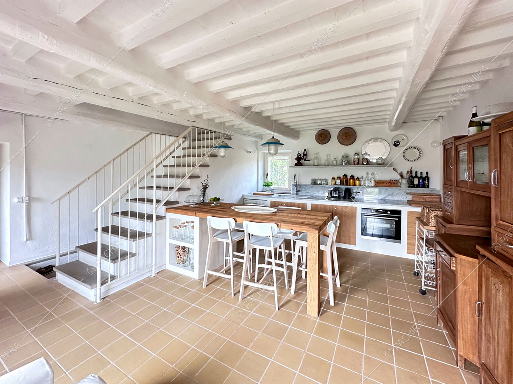 Cucina a parete con credenza in legno, tavolo da pranzo e vista sulle scale