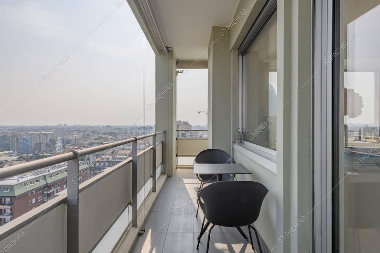 Pavimento in piastrelle grigie e tavolo da esterni nero sulla terrazza