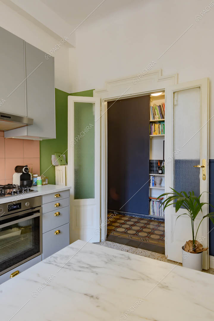 Tavolo da pranzo con piano in marmo nella cucina a parete con paraschizzi rosa