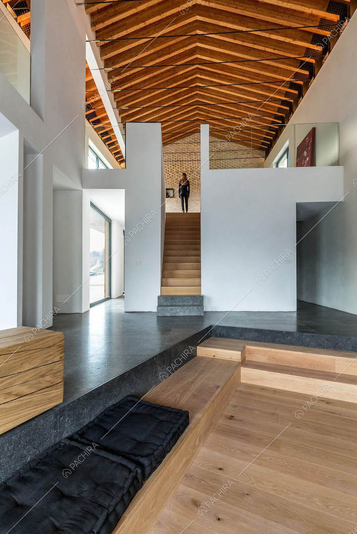 Pavimento in parquet e in marmo nero nell'open space dall'alto soffitto in travi in legno