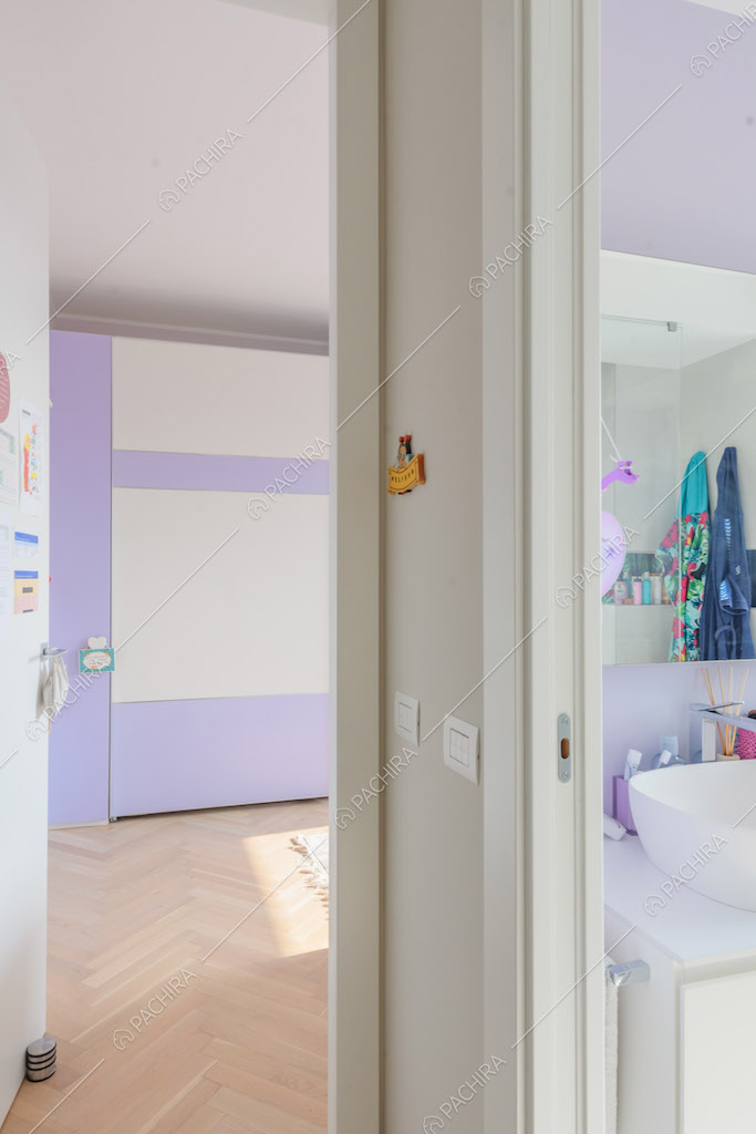 Vista sul bagno con parete lilla e sulla camera da letto dei bambini