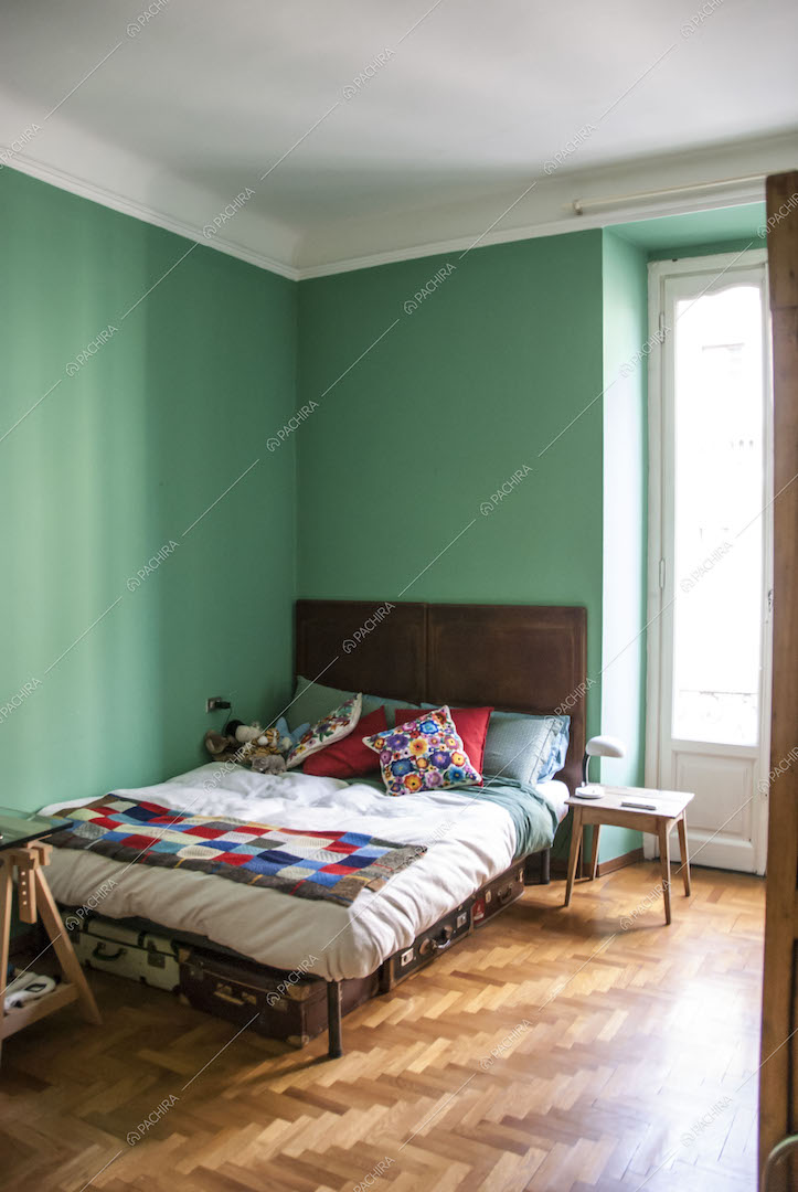 Camera da letto con pareti verdeacqua e pavimento in parquet
