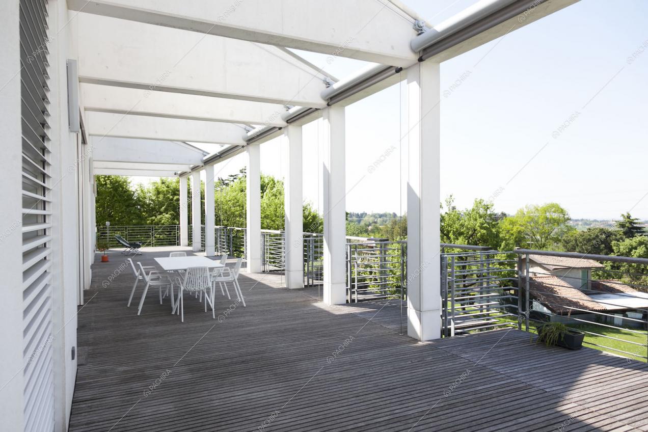 Terrazza con pavimento in legno, tavolo da pranzo e vista