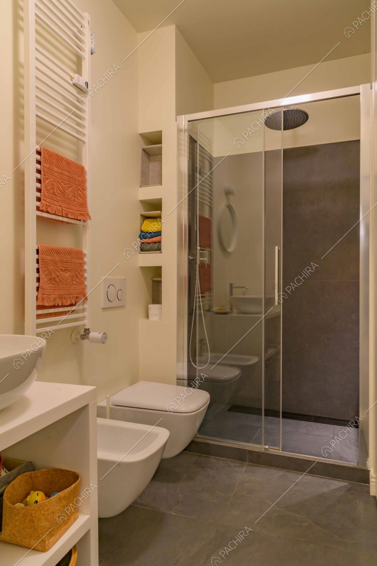 Grande box doccia dalle pareti in pietra grigia nel bagno