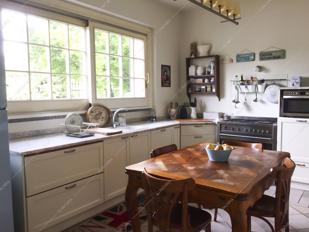 Cucina a parete bianca e tavolo da pranzo in legno