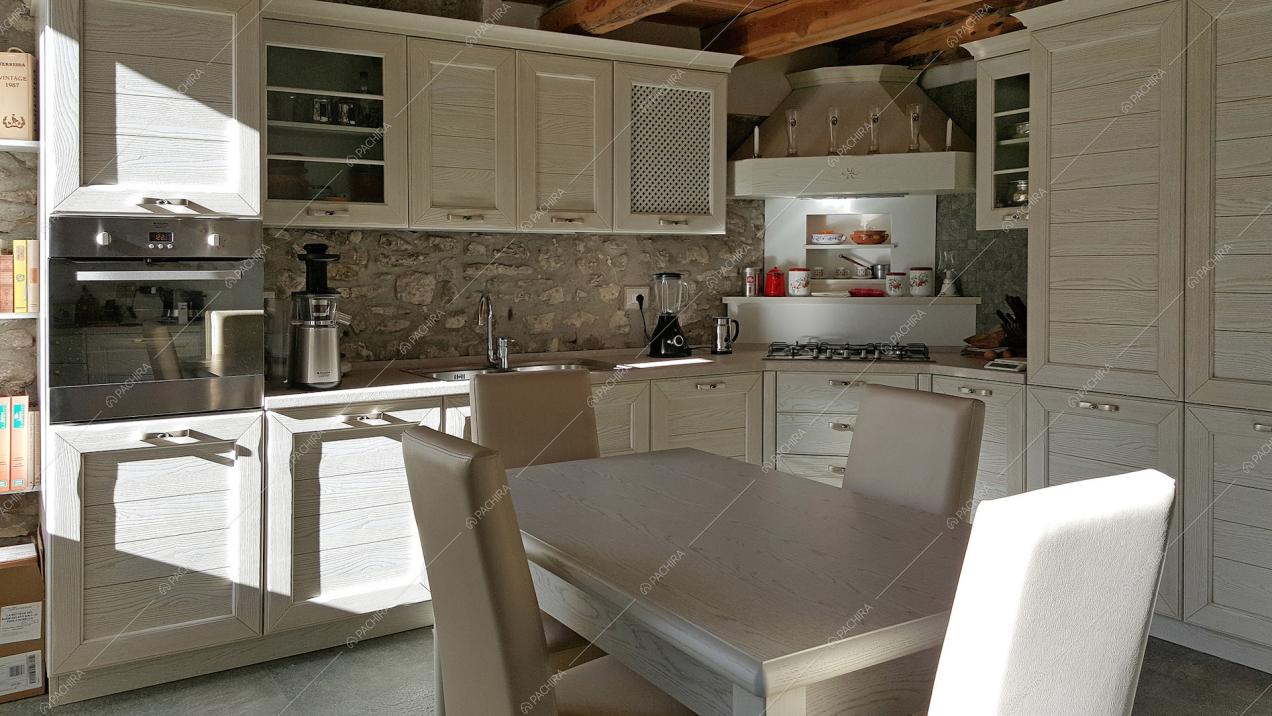 Visuale su cucina in legno con pareti in pietra viva