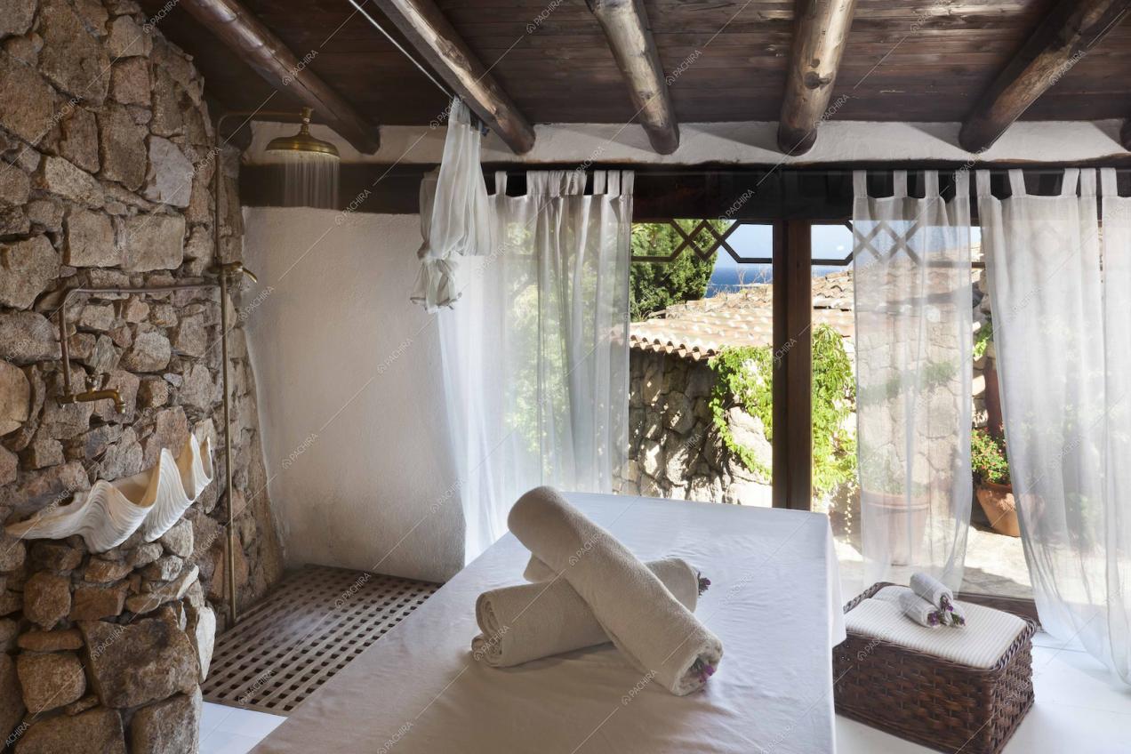 Doccia, pareti in pietra e soffitto con travi a vista nella spa
