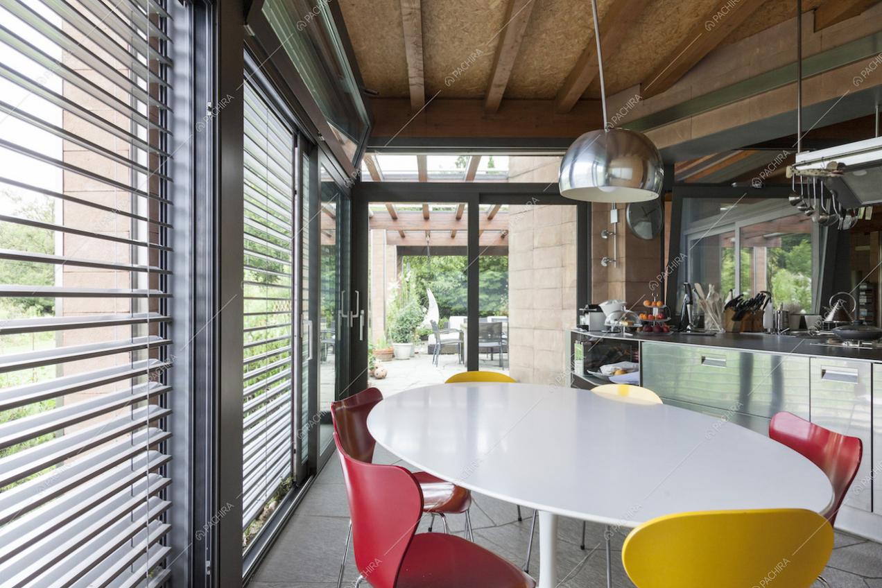 Tavolo da pranzo con sedie colorate in cucina e vista sull'esterno