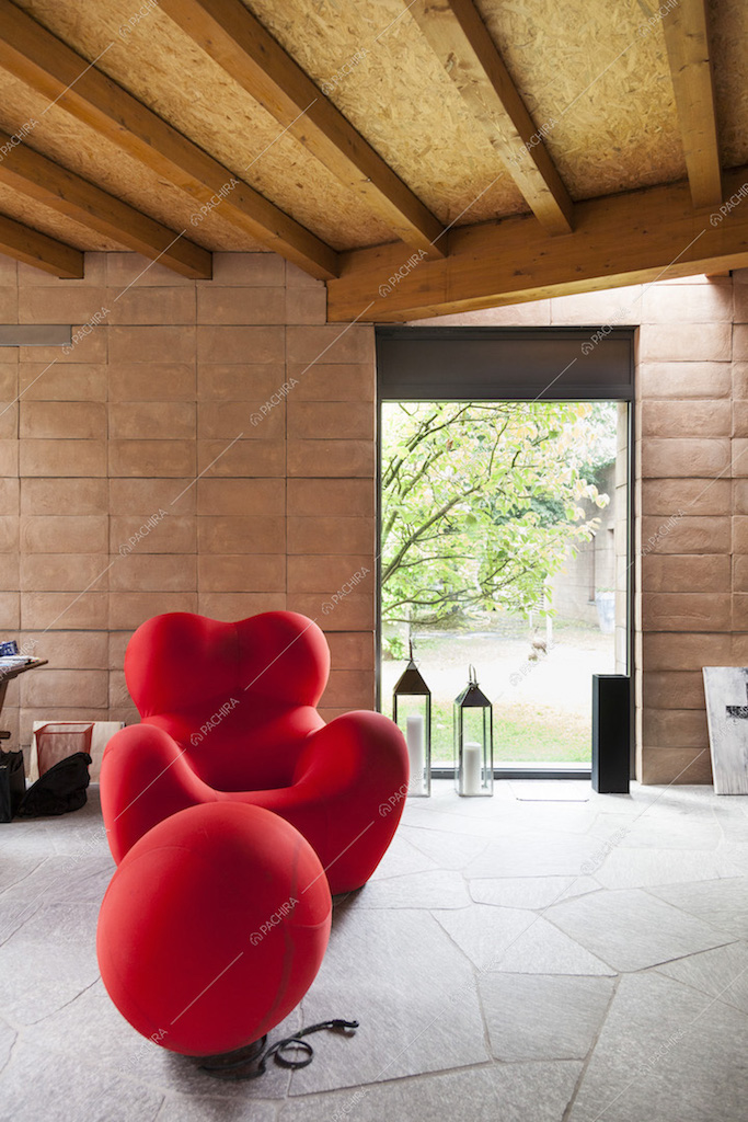 Poltrona rossa di design e vetrata nella zona living