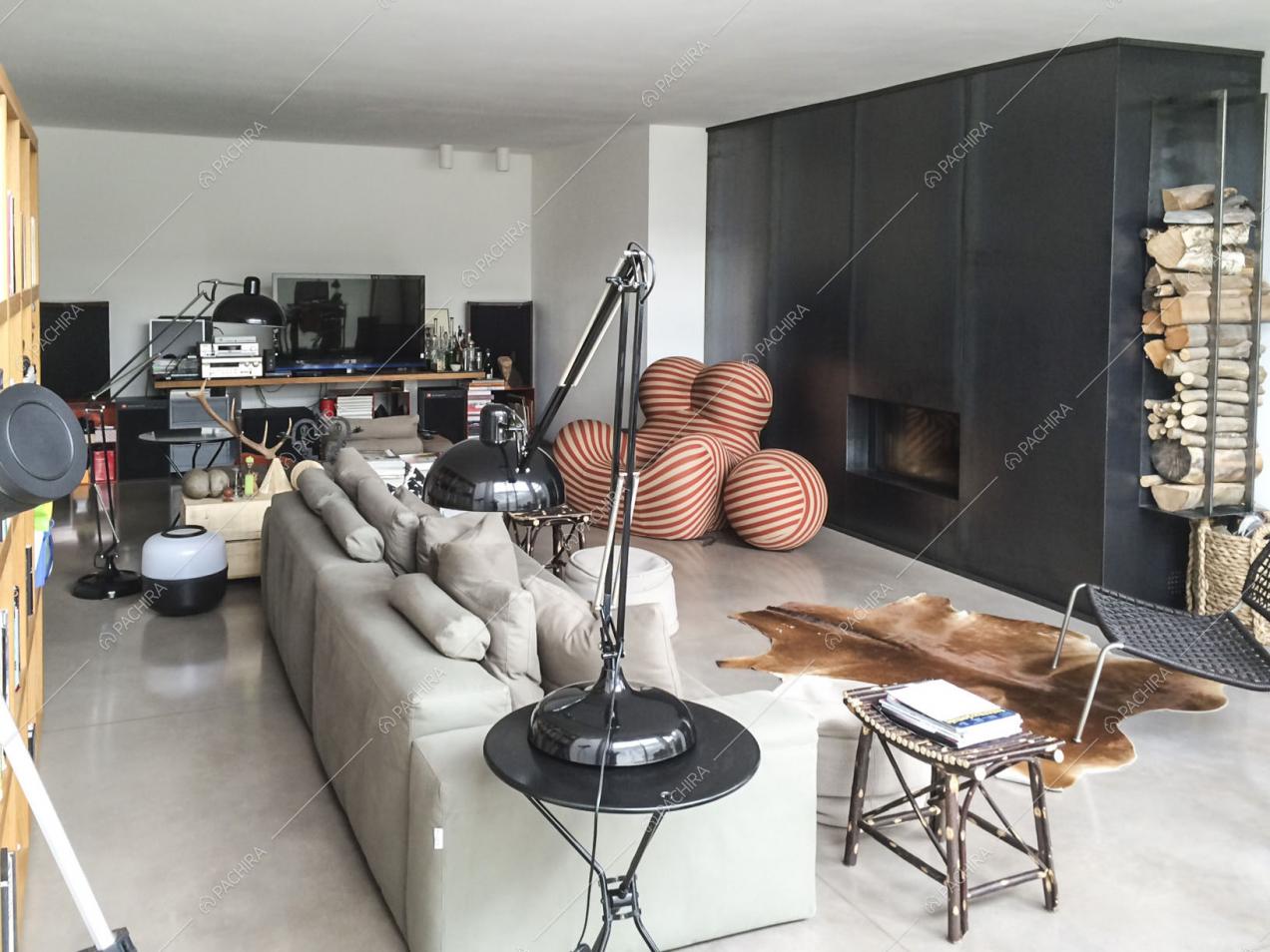 Zona living con divano, poltrona di design e camino