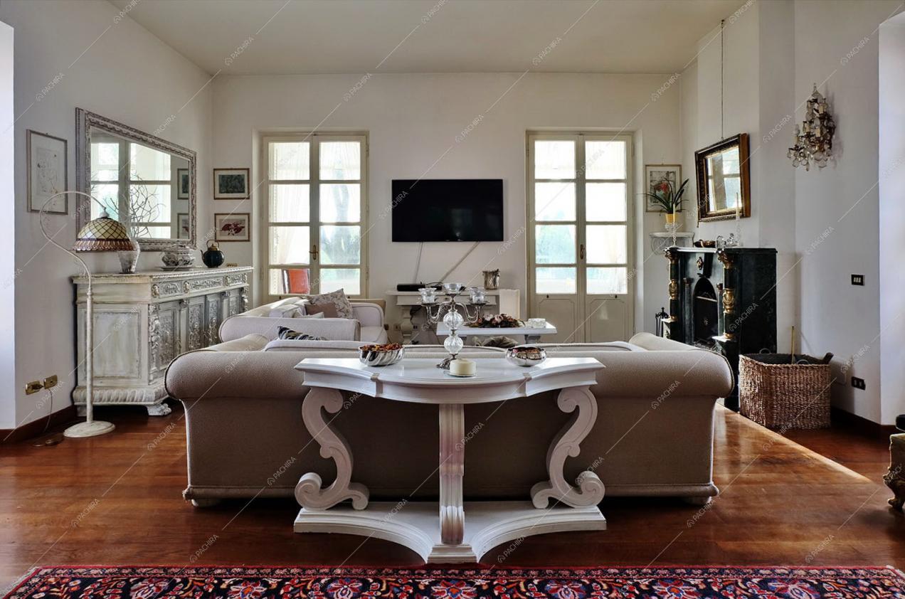 Zona living  con pavimento in parquet, camino e mobili d'epoca