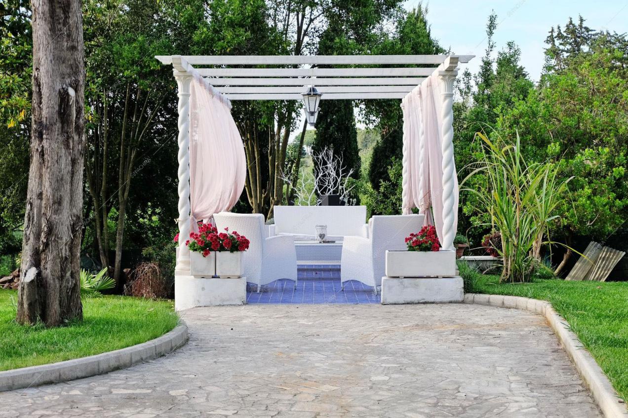 Selciato che porta al gazebo con divanetti in vimini