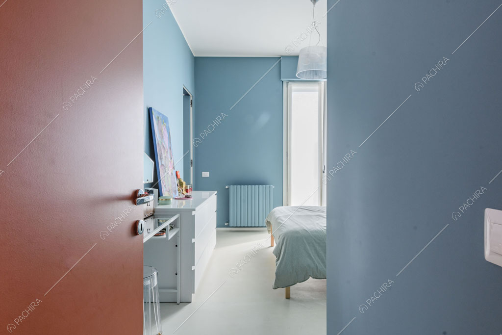 Pareti azzurre della camera da letto dell'appartamento Papagayo, location in stile contemporaneo a Milano