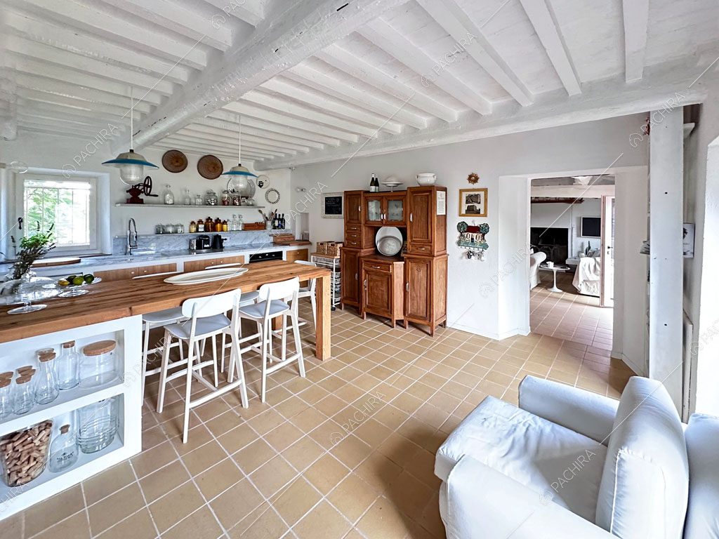 Poltrona bianca nella luminosa cucina a parete con vista sulla zona living