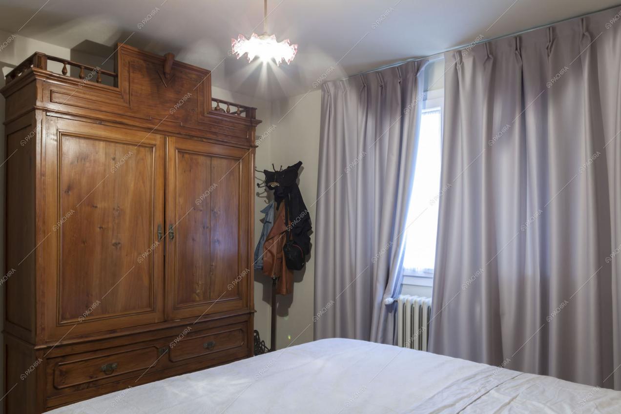 Luminosa camera da letto matrimoniale con ampio armadio in legno