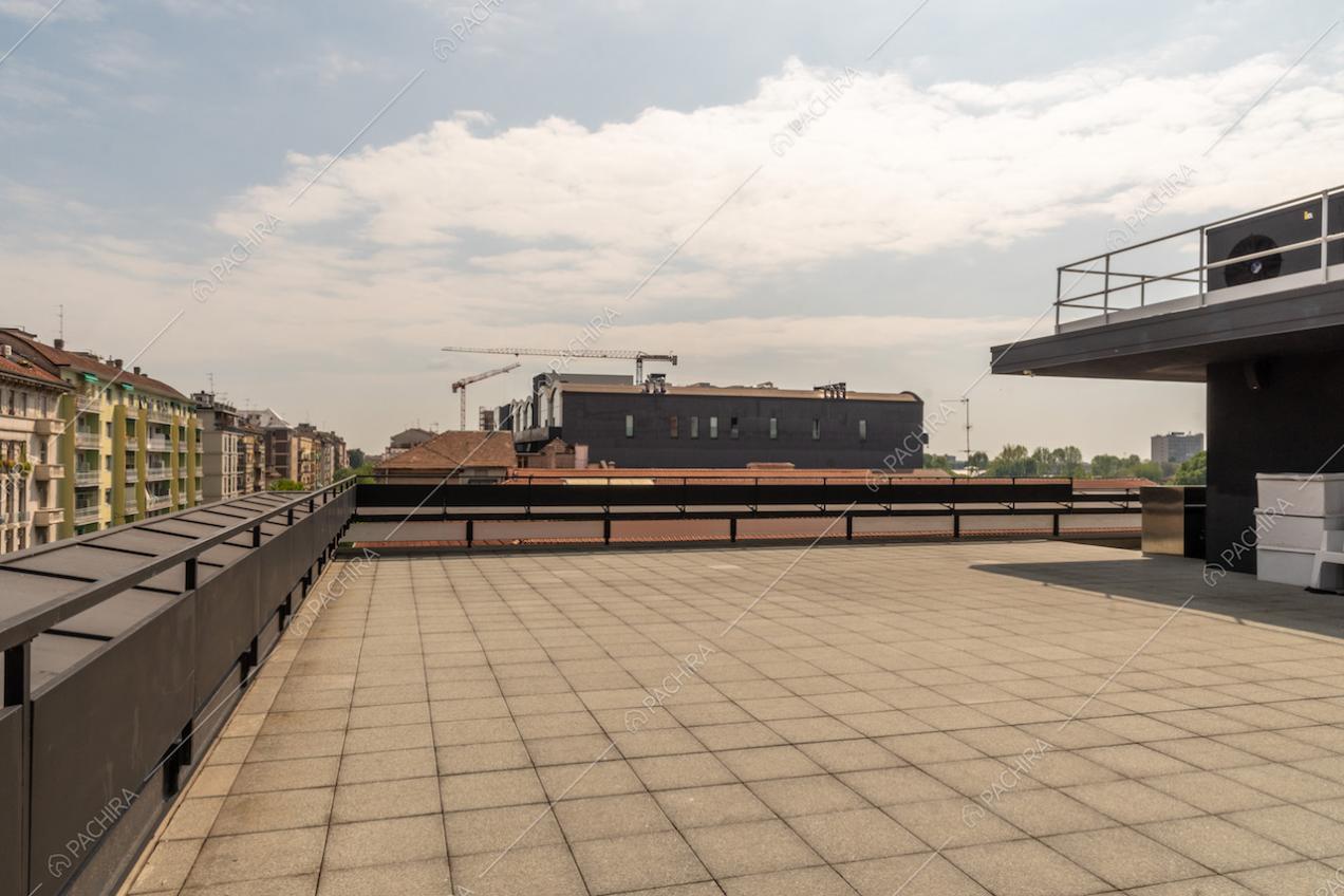 Ampia terrazza con vista sullo skyline di Milano e con pavimentazione in piastrelle da esterno