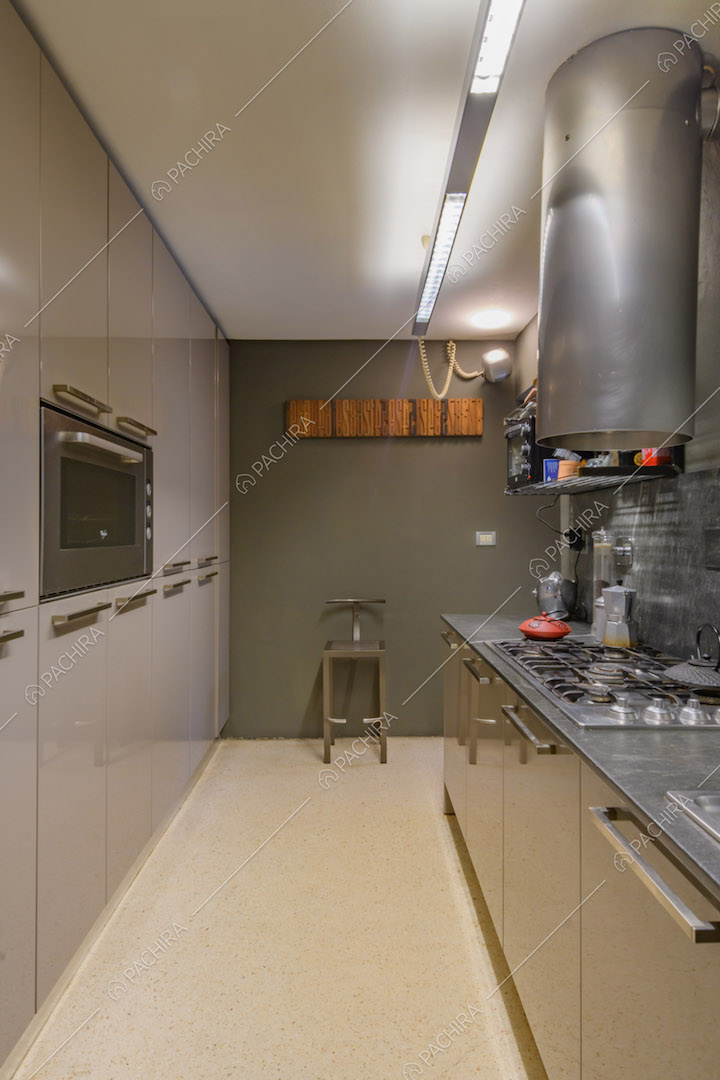 Grande cucina a parete con fornelli a gas e parete verde scuro