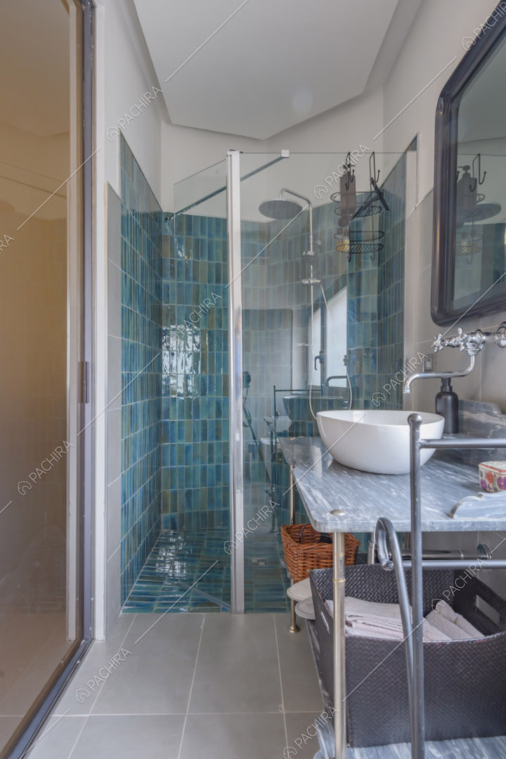 Bagno della camera da letto con piastrelle azzurre nel box doccia