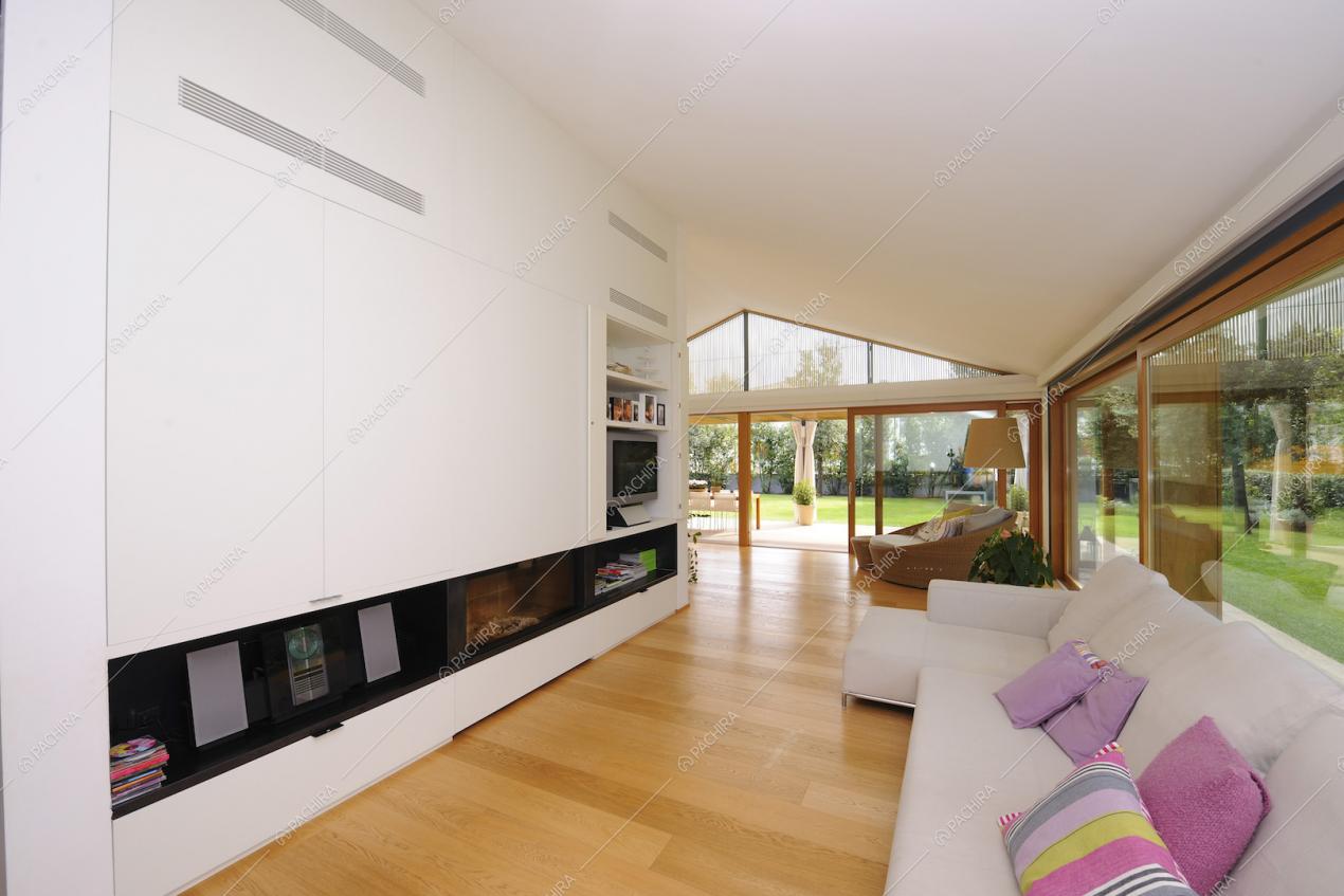 Sala minimal con ampie vetrate sul giardino