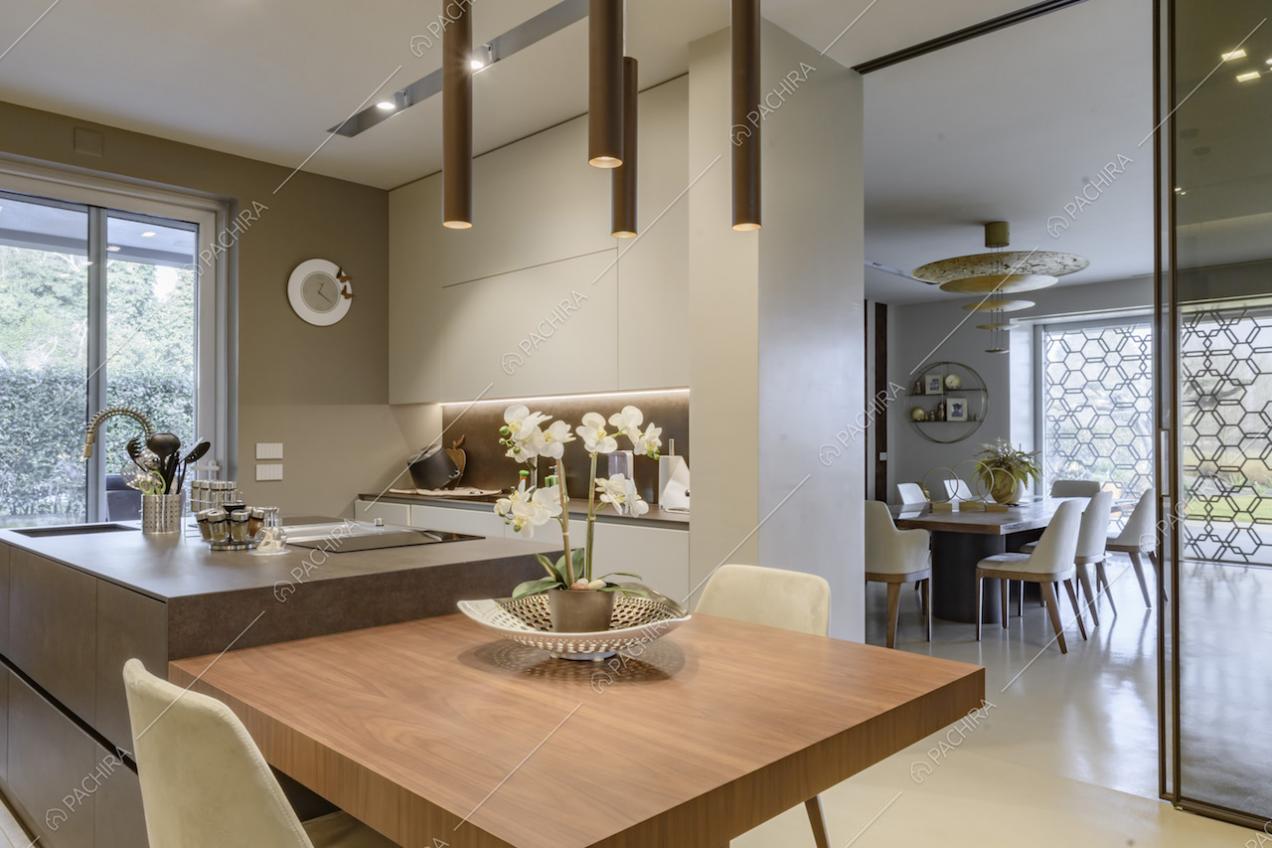 Cucina con isola e lampade di design con vista sul tavolo da pranzo nella sala