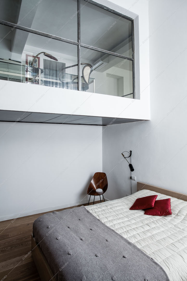 Camera da letto con vista sul soppalco con vetrata
