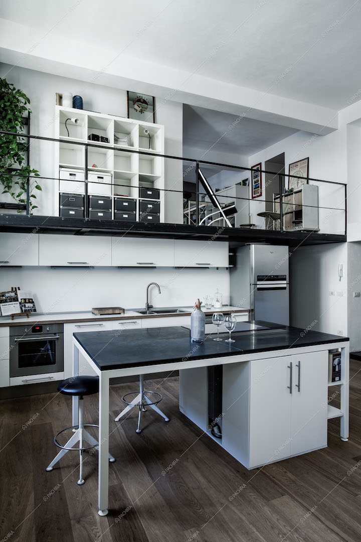 Cucina con isola e sgabelli, soppalco in metallo nero