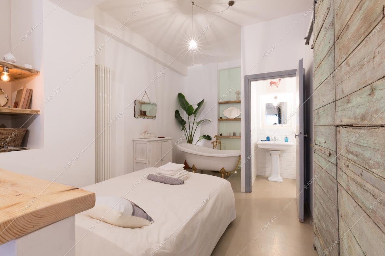 Camera da letto con vasca, ingresso del bagno e pavimento in resina