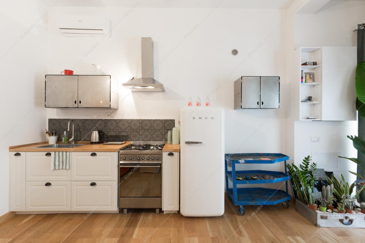 Cucina a vista con fornelli a gas e pavimento in parquet