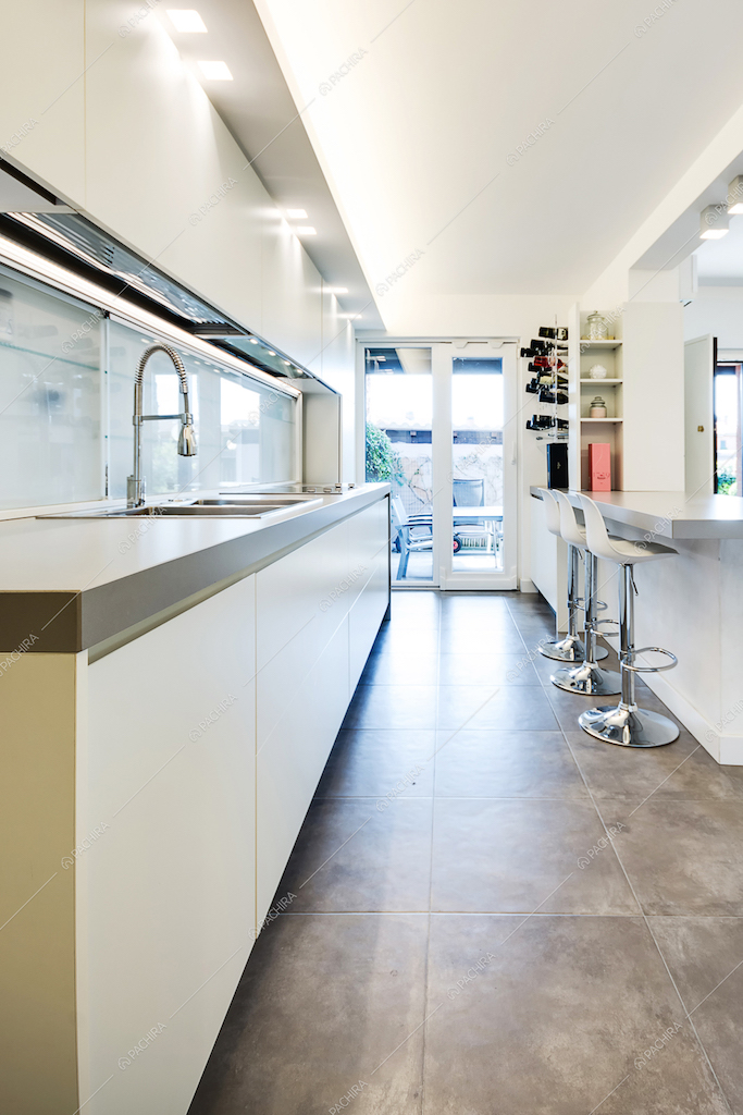 Cucina con penisola e pavimento in cemento armato