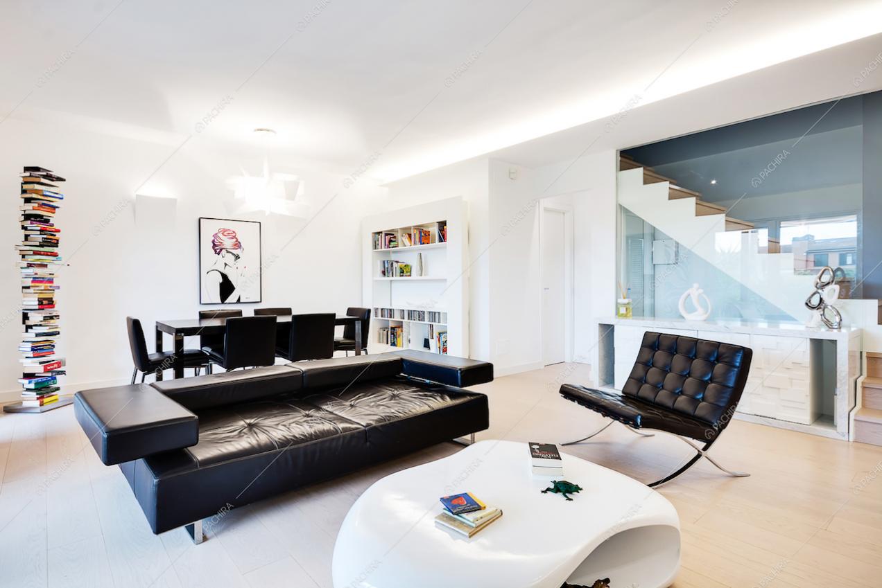 Zona living tavolino bianco, divano e poltrona neri