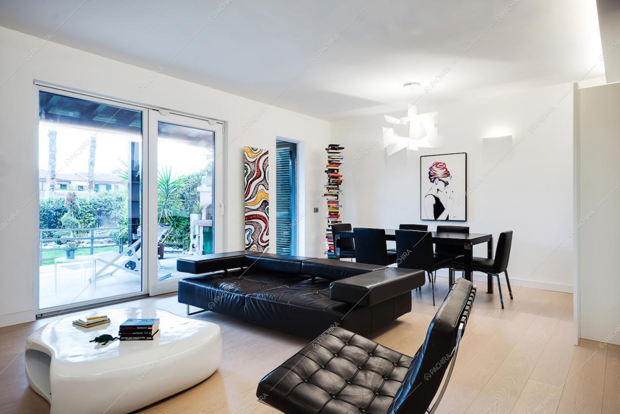 Zona living con divano e poltrona neri in pelle