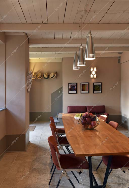 Sala da pranzo con arredi essenziali e illuminazione di design