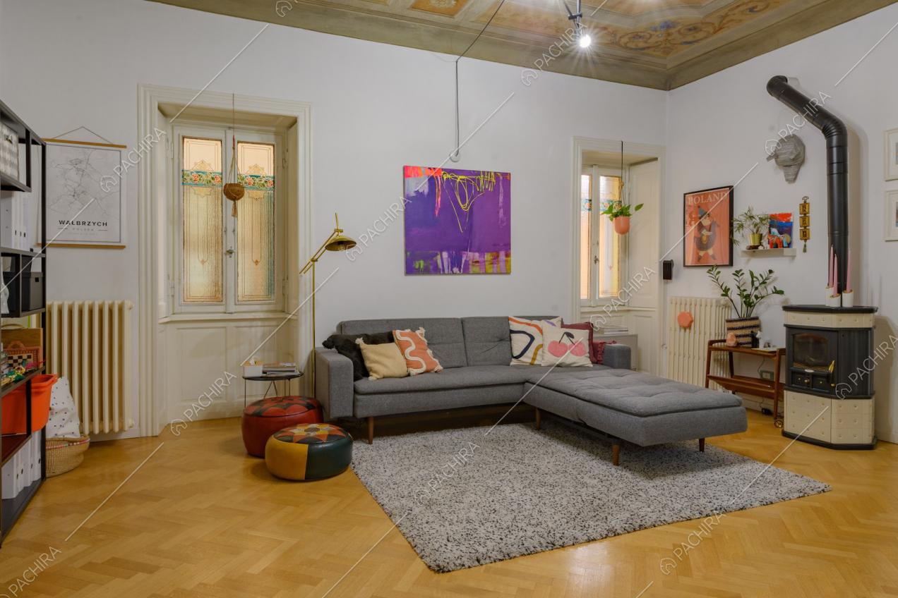 Soffitto affrescato nella sala con pareti bianche e pavimento in parquet a spina di pesce