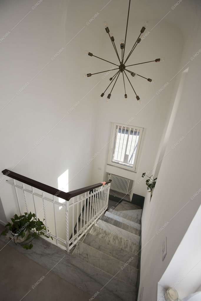 Inquadratura delle scale in marmo dall'alto e lampadario di design