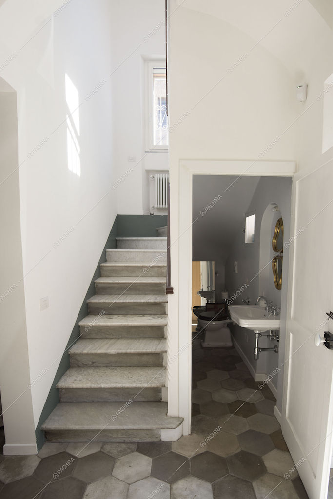 Scale e bagno nel sottoscala con pavimento a cementine esagonali grigie